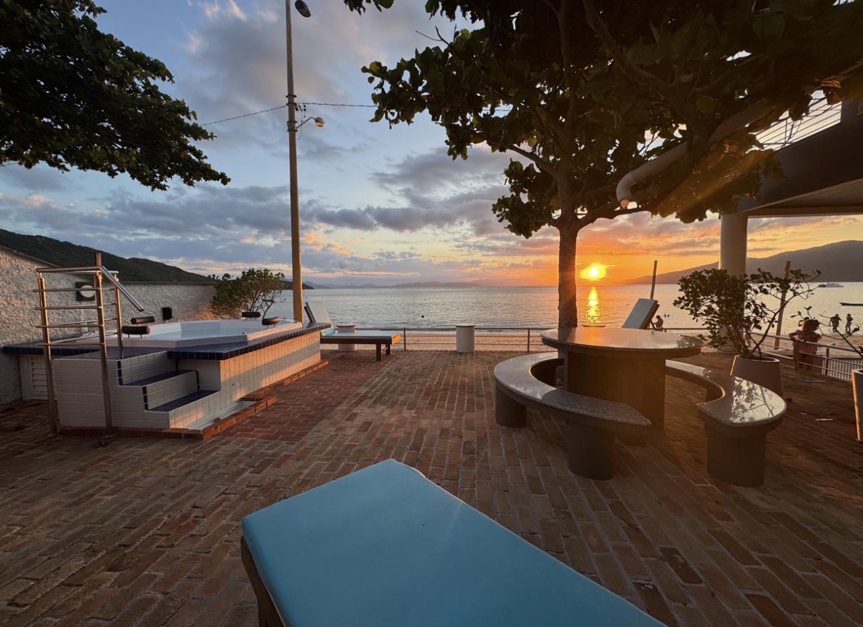 Current beachfront patio and hot tub photographed at sunset