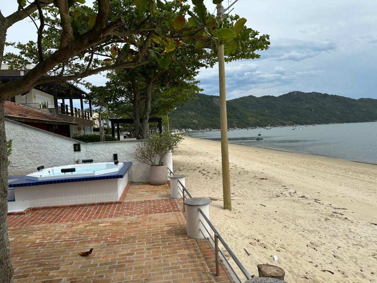 Earlier wide view of the beachfront patio and hot tub during daytime